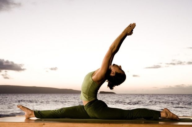 yoga-lehre-frau-grün-kleider-trainieren-meer-draußen.jpg